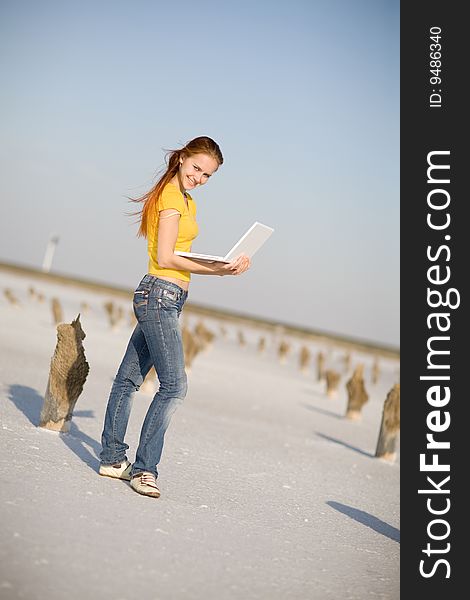 Happy girl with notebook on the sand