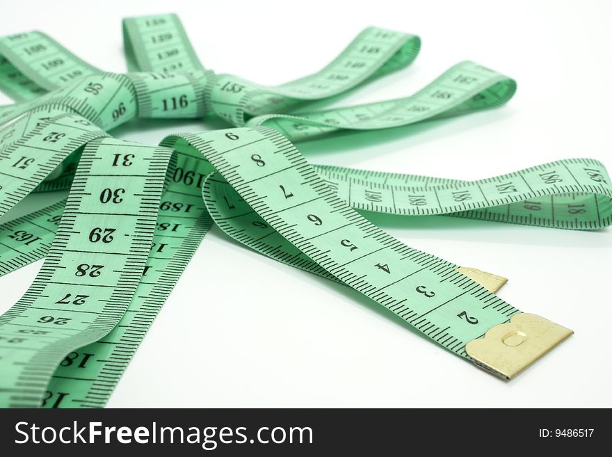 Green tape measure on white background in the form of a star