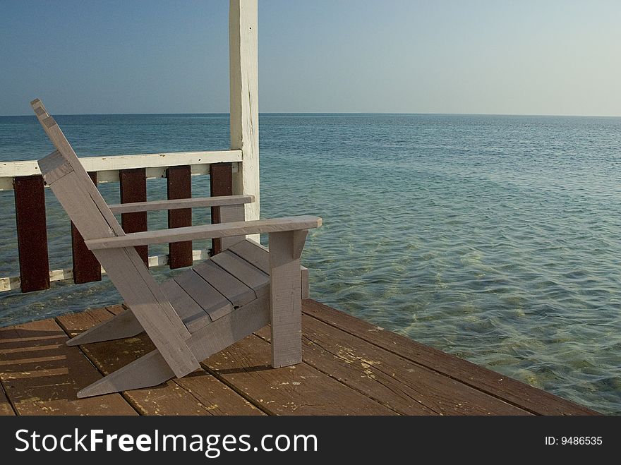 A chair on the veranda of a bungalow over looking the Caribbean Sea. A chair on the veranda of a bungalow over looking the Caribbean Sea