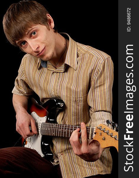 Young musician playing electric guitar isolated on black. Young musician playing electric guitar isolated on black