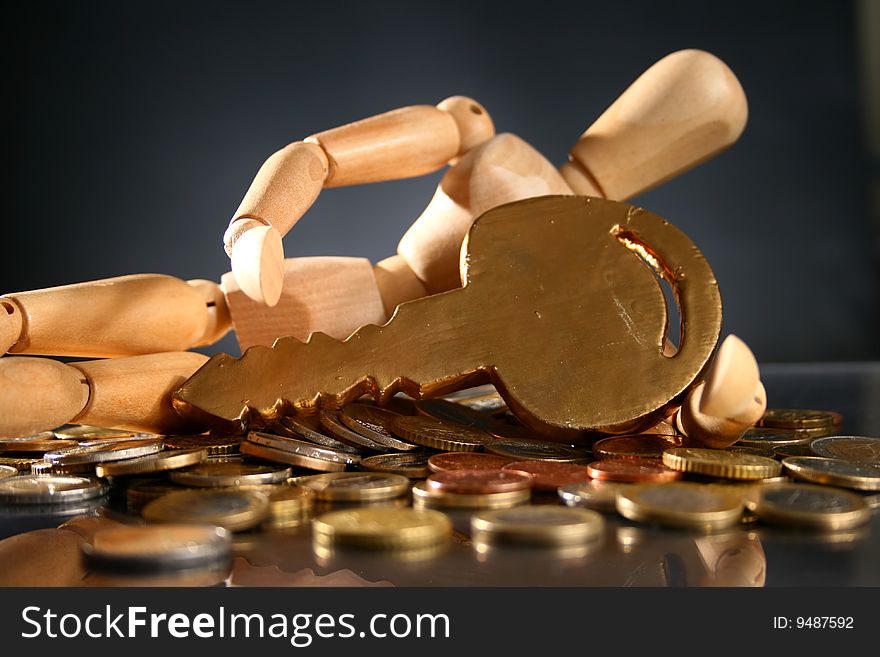 Wooden man, golden key and lot of coins. Wooden man, golden key and lot of coins.