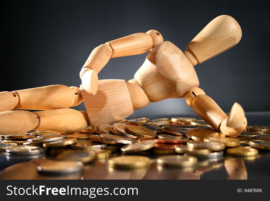 Financial conceptual image. Wooden man and coins. Financial conceptual image. Wooden man and coins.