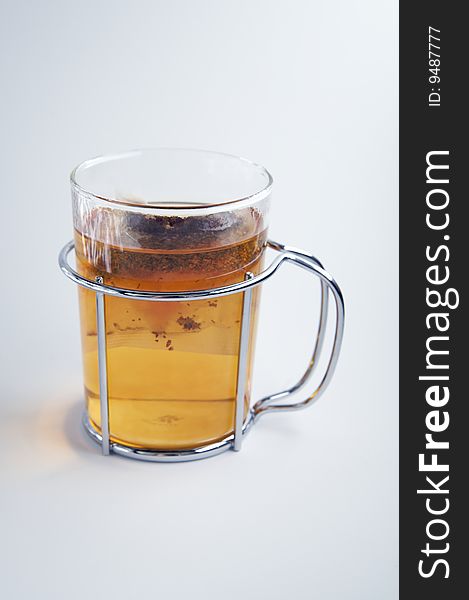 A clear glass, with metal holder, with teabag inside. A clear glass, with metal holder, with teabag inside.