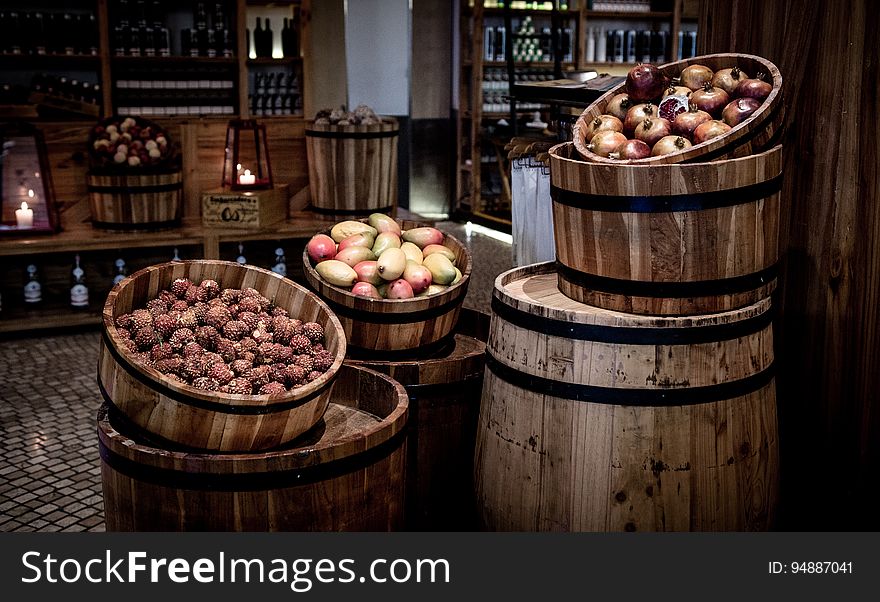 Kegs with fruits on barrels in a basement.