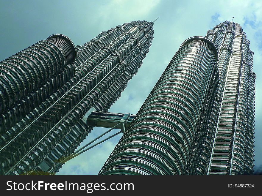 Low angle of twin skyscraper Petronas Towers against blue skies in Malaysia. Low angle of twin skyscraper Petronas Towers against blue skies in Malaysia.