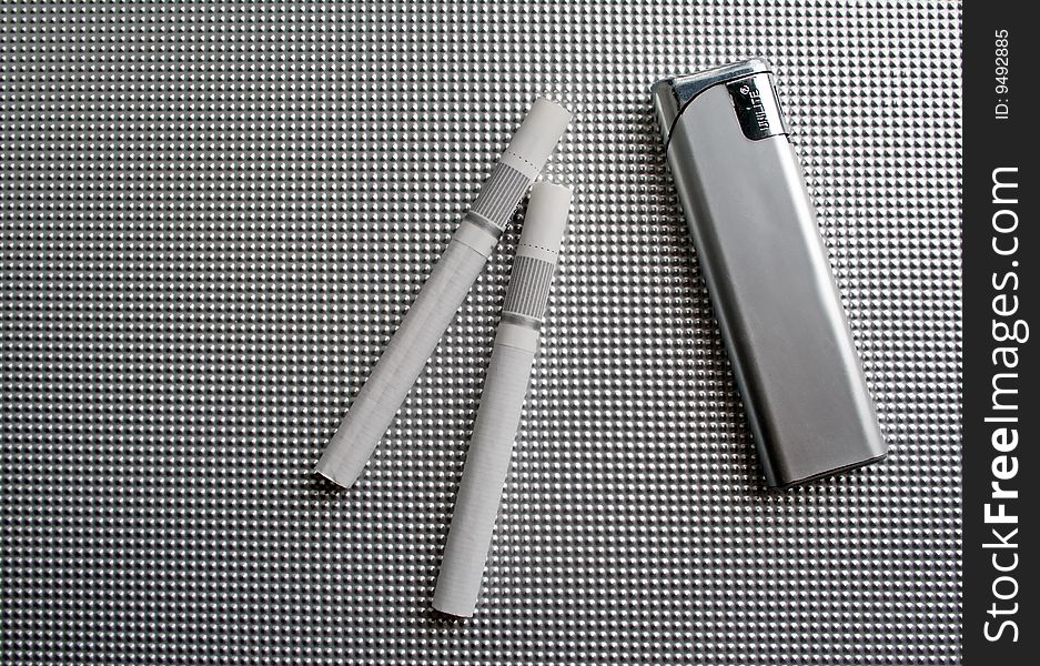 Lighter and cigarettes on a grey background