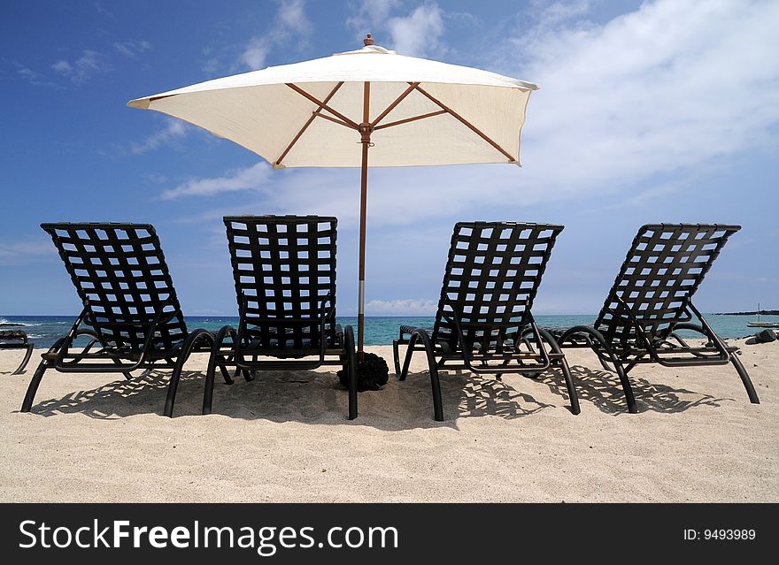 Four beach chairs sit before a beautiful ocean view. Four beach chairs sit before a beautiful ocean view.