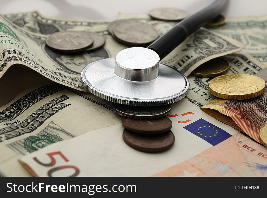 Some dollar coins and bills and Stethoscope. Some dollar coins and bills and Stethoscope