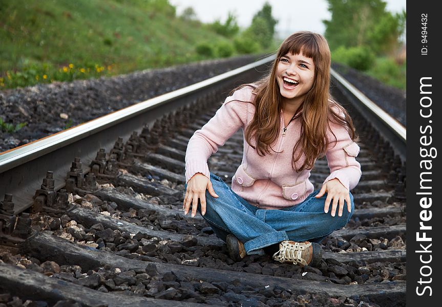 The young beautiful  girl sits on railway