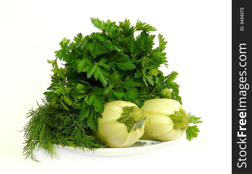 Fresh curly parsley and two marrows on the plate isolated over white background. Fresh curly parsley and two marrows on the plate isolated over white background