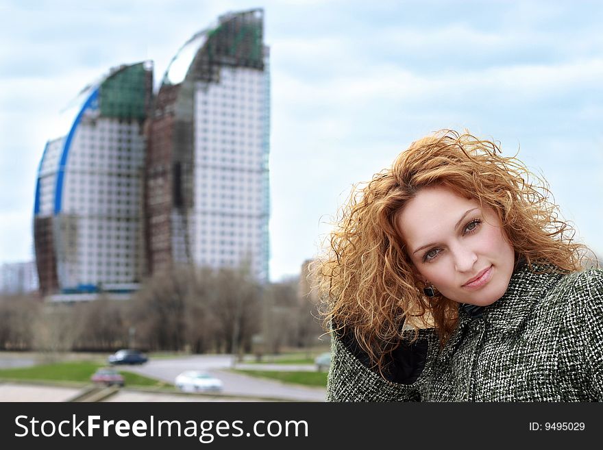 Portrait of beautiful young woman. Urban scene on background.