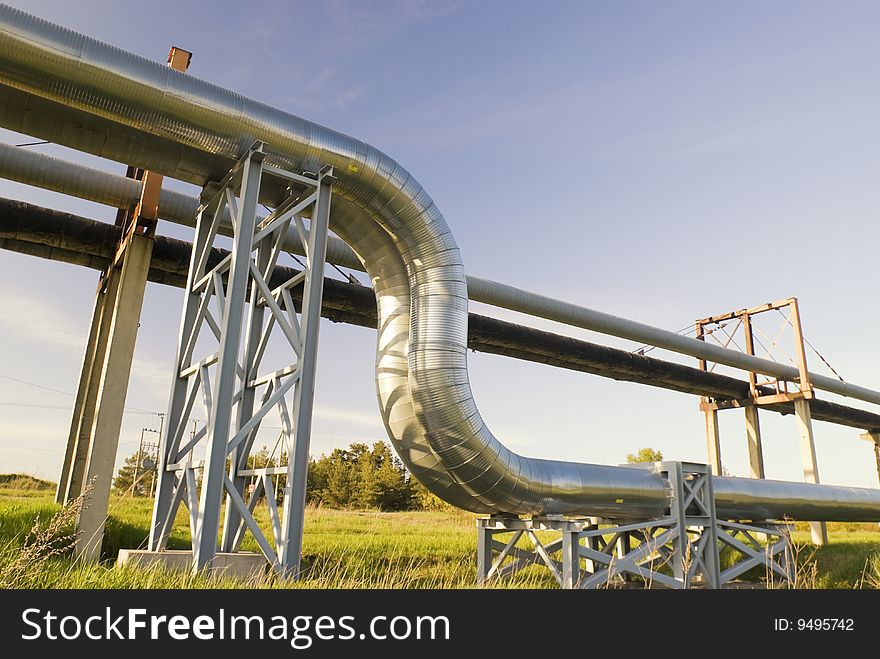 Industrial pipelines on pipe-bridge against blue sky. Industrial pipelines on pipe-bridge against blue sky.