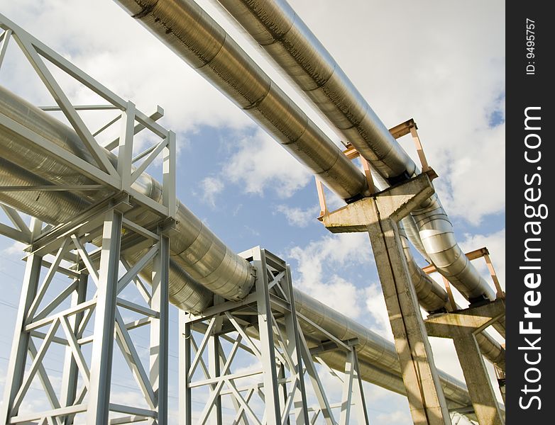 Industrial pipelines on pipe-bridge against blue sky. Industrial pipelines on pipe-bridge against blue sky.