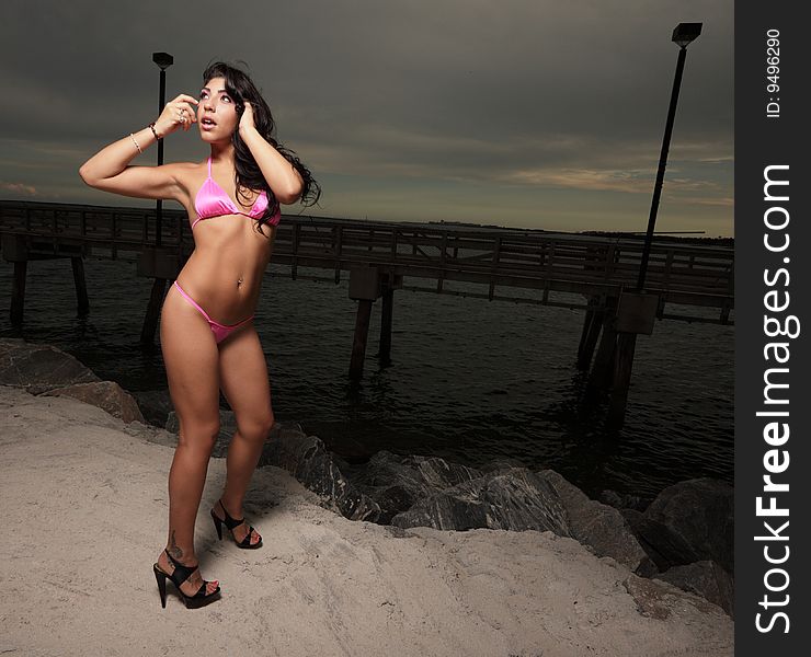 Young woman in a pink bikini glancing away. Young woman in a pink bikini glancing away