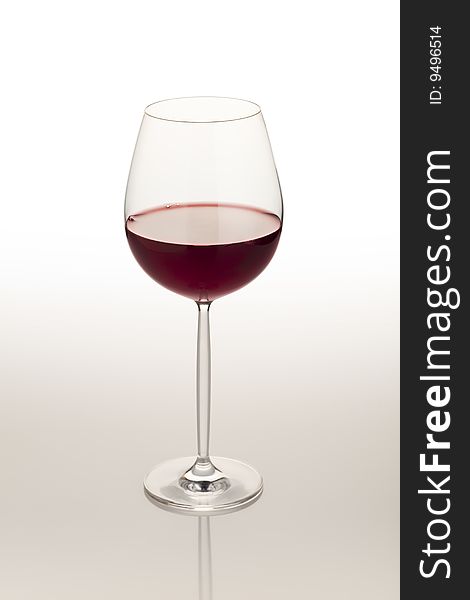 Red wine glass on reflective white table. Red wine glass on reflective white table