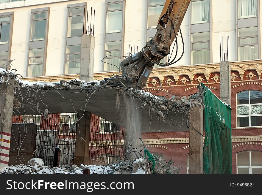 Heavy dredger is demolishing a house. Heavy dredger is demolishing a house