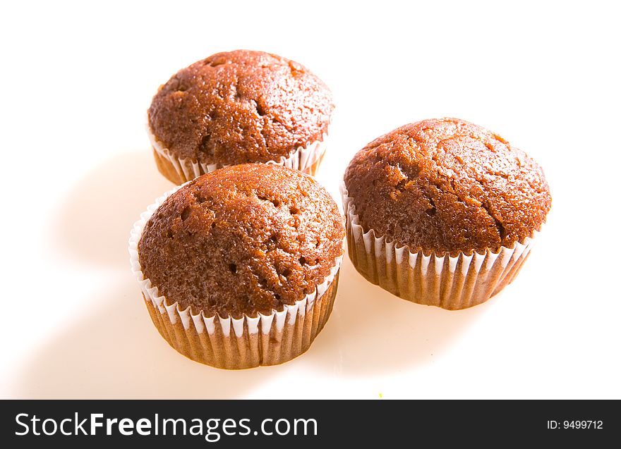 Three chocolate muffins on white ground