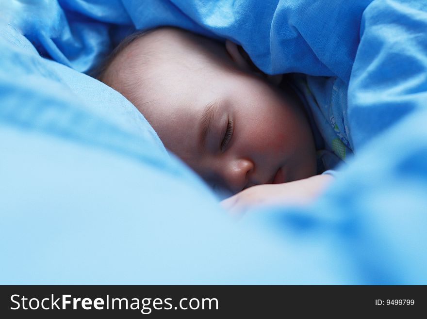 Sleeping baby close up on blue pastel linen. Sleeping baby close up on blue pastel linen