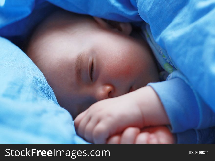 Sleeping baby close up on blue pastel linen. Sleeping baby close up on blue pastel linen