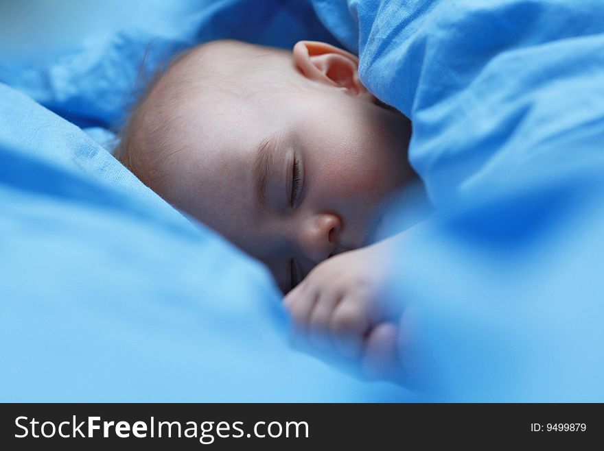 Sleeping baby close up on blue pastel linen. Sleeping baby close up on blue pastel linen