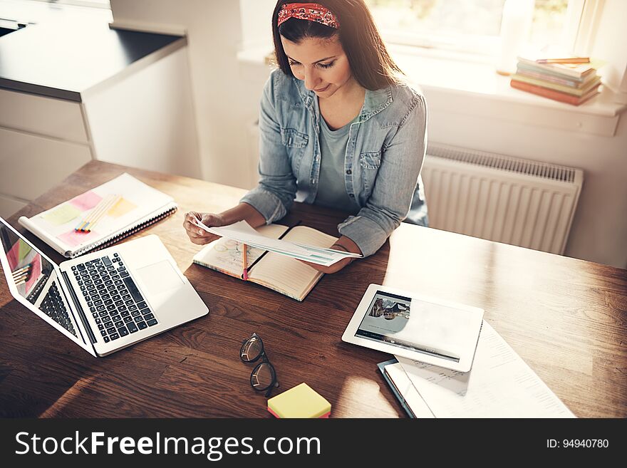 Pretty young businesswoman sitting at workplace in office and working with documents. Pretty young businesswoman sitting at workplace in office and working with documents.