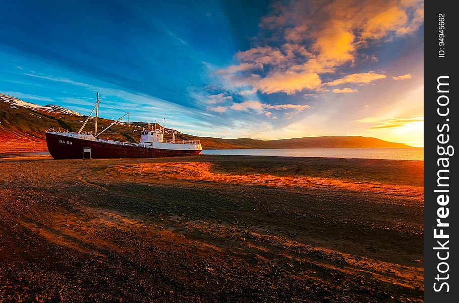 A sunset on a beach with a ship drawn ashore. A sunset on a beach with a ship drawn ashore.