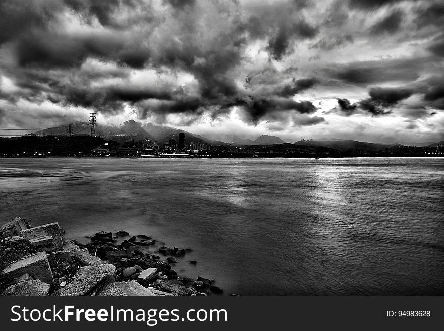 Grayscale Photo of Sea during Cloudy Sky at Daytime