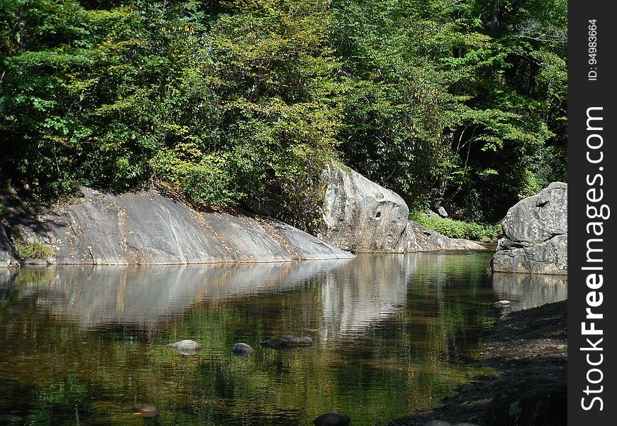 Boulders on riverfront in woods on sunny day. Boulders on riverfront in woods on sunny day.