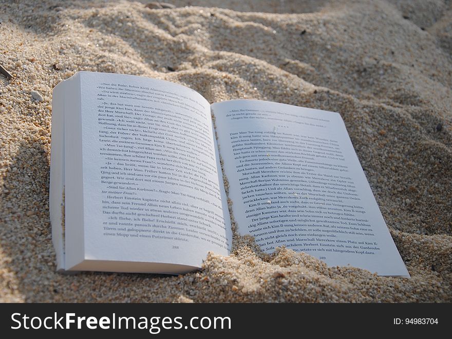 White Book On Sand During Daytime