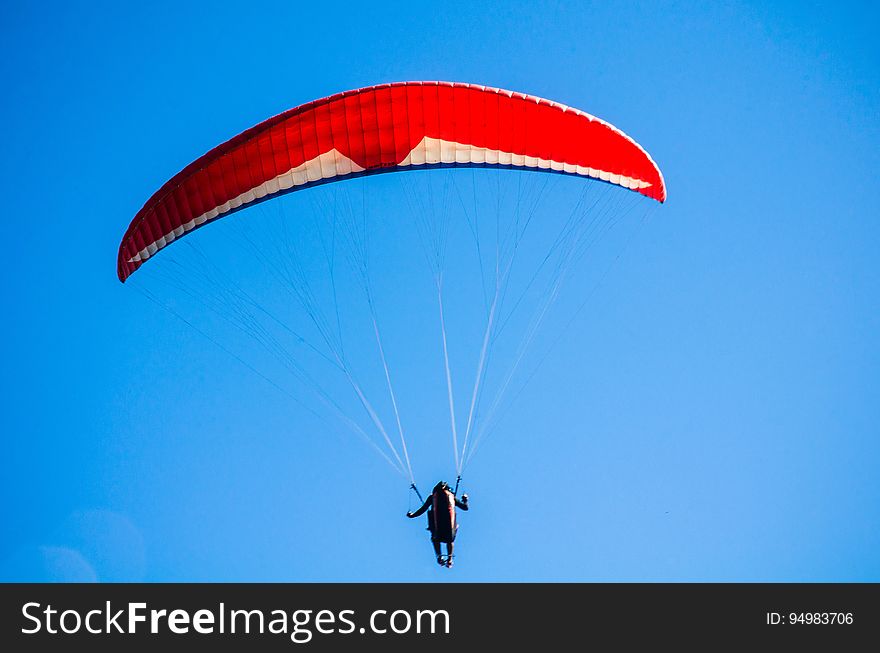 Person Using Red Parachute on Mid Air