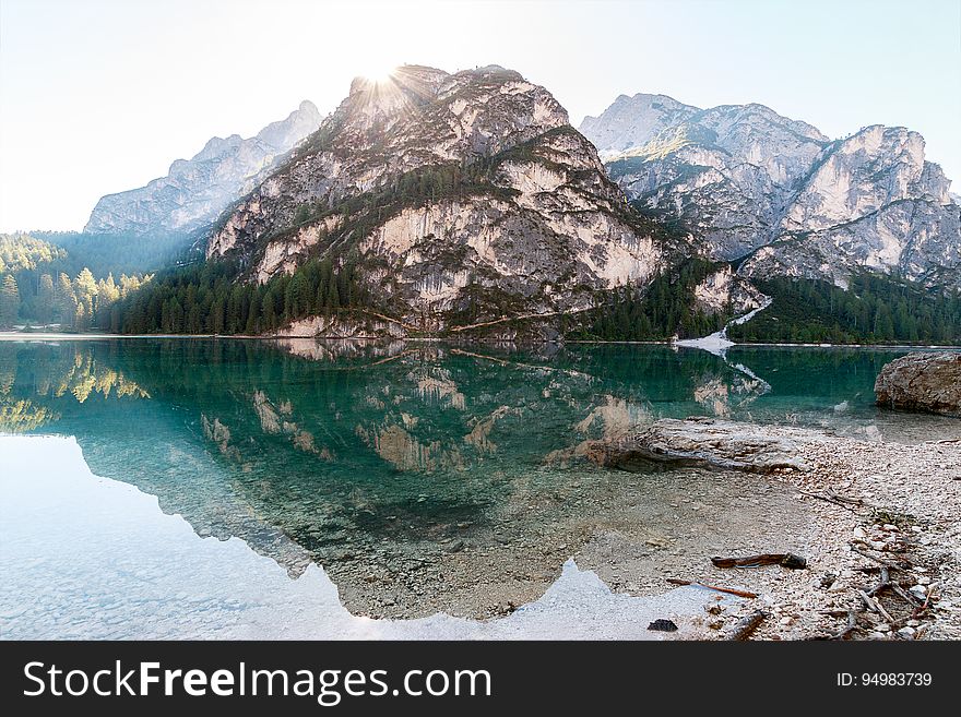 Boulder reflecting in clear waters of alpine lake on sunny day. Boulder reflecting in clear waters of alpine lake on sunny day.