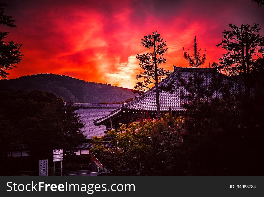 Sunset over rooftops in a traditional Asian city.