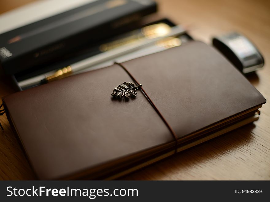 A journal and writing supplies on a desk. A journal and writing supplies on a desk.