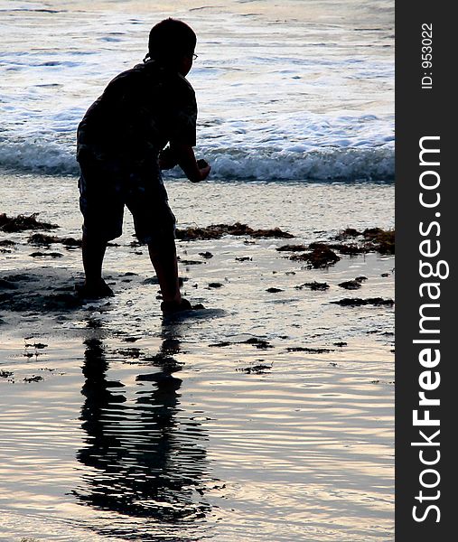 Silhouette of young boy playing at the seashore. Silhouette of young boy playing at the seashore