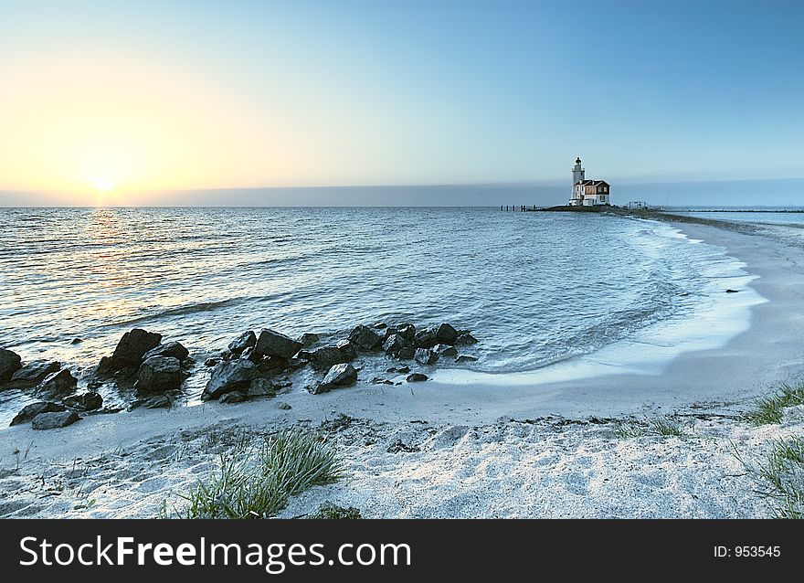 A beautiful beach and lighthouse at sunrise. A beautiful beach and lighthouse at sunrise