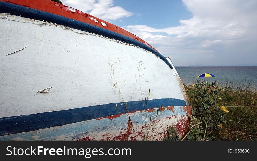 Old boat with umbrella at beach