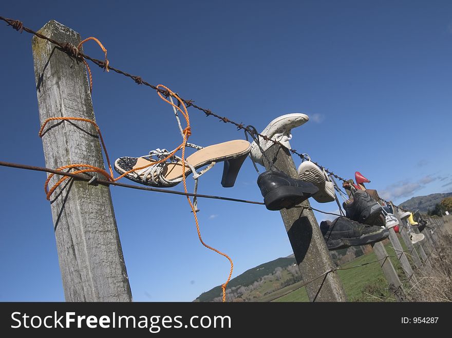 Shoes hanging from barbed wire fence in the wilderness, New Zealand. Shoes hanging from barbed wire fence in the wilderness, New Zealand