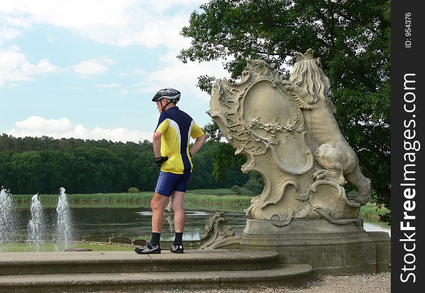 Biker at a fountain i a baroque castle garden. Biker at a fountain i a baroque castle garden