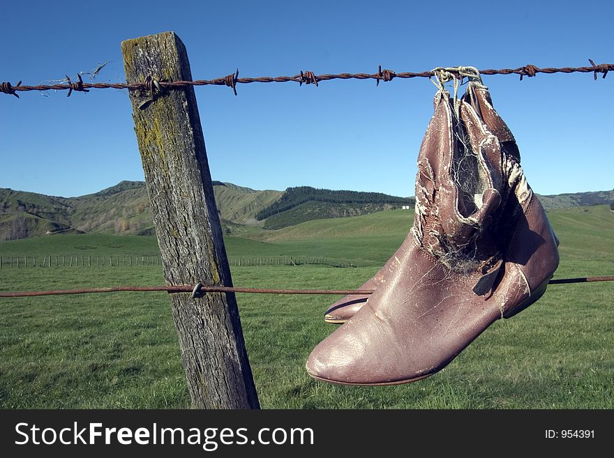 Shoes hanging from barbed wire fence in the wilderness, New Zealand. Shoes hanging from barbed wire fence in the wilderness, New Zealand