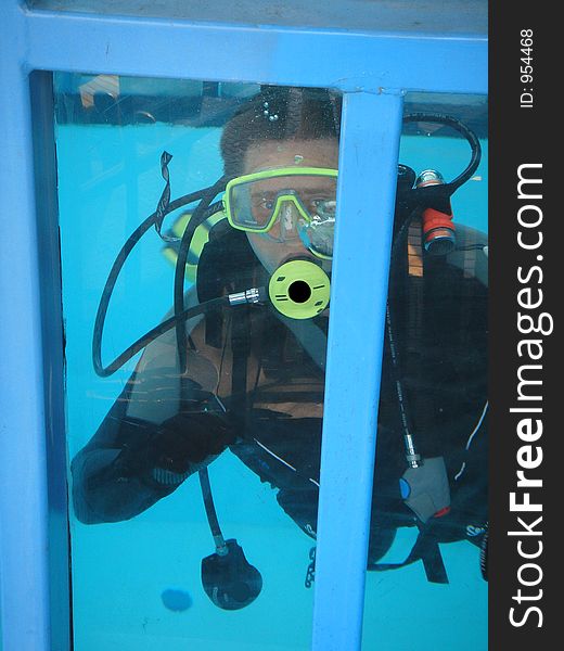 Diver in metal box in the water