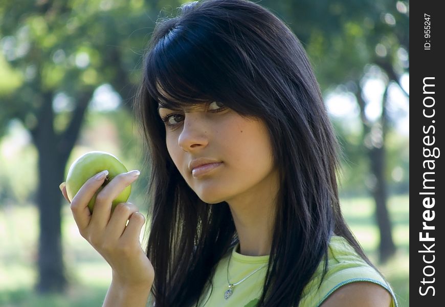 Beautiful young woman holding green apple in hand. Beautiful young woman holding green apple in hand