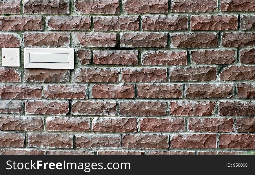 Brick wall with post box and door bell switch