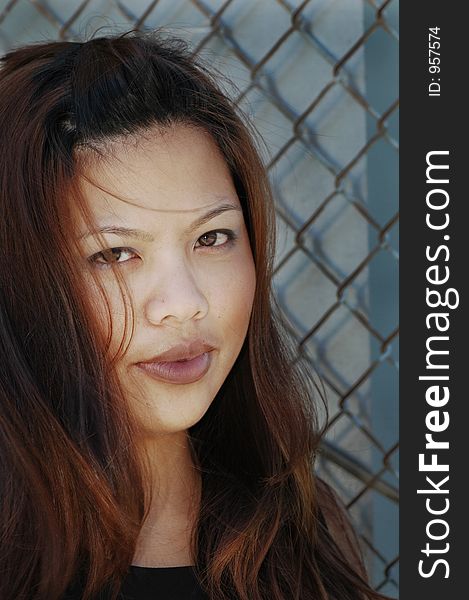 Woman in front of fence, hair down