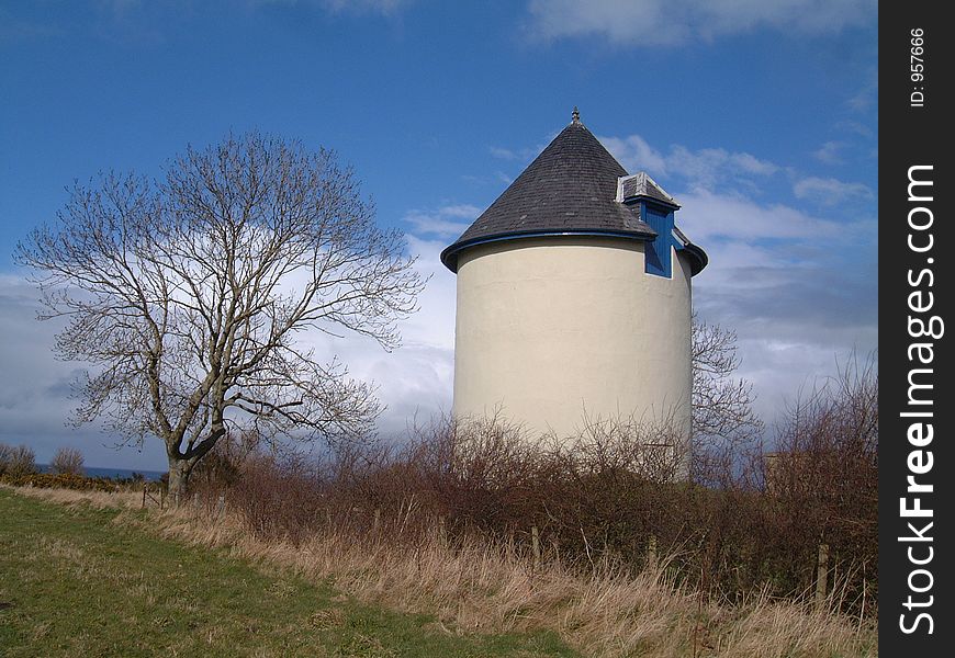 Wter tower standing beside a bare tree.
looks very similar to dovecote. Blue sky with white clouds in background. Wter tower standing beside a bare tree.
looks very similar to dovecote. Blue sky with white clouds in background.