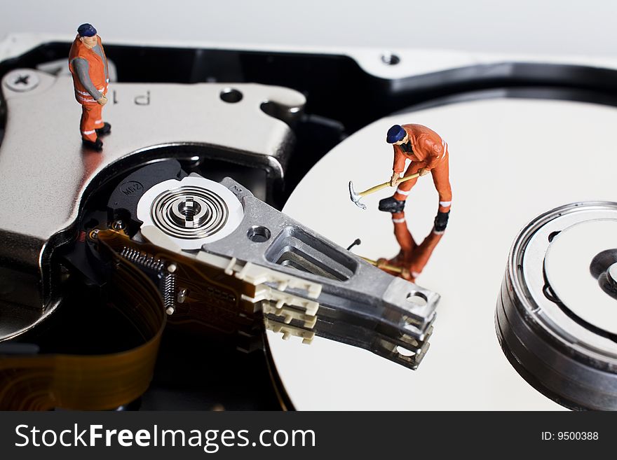 Worker figurine placed on hard drive on white backdrop. Worker figurine placed on hard drive on white backdrop