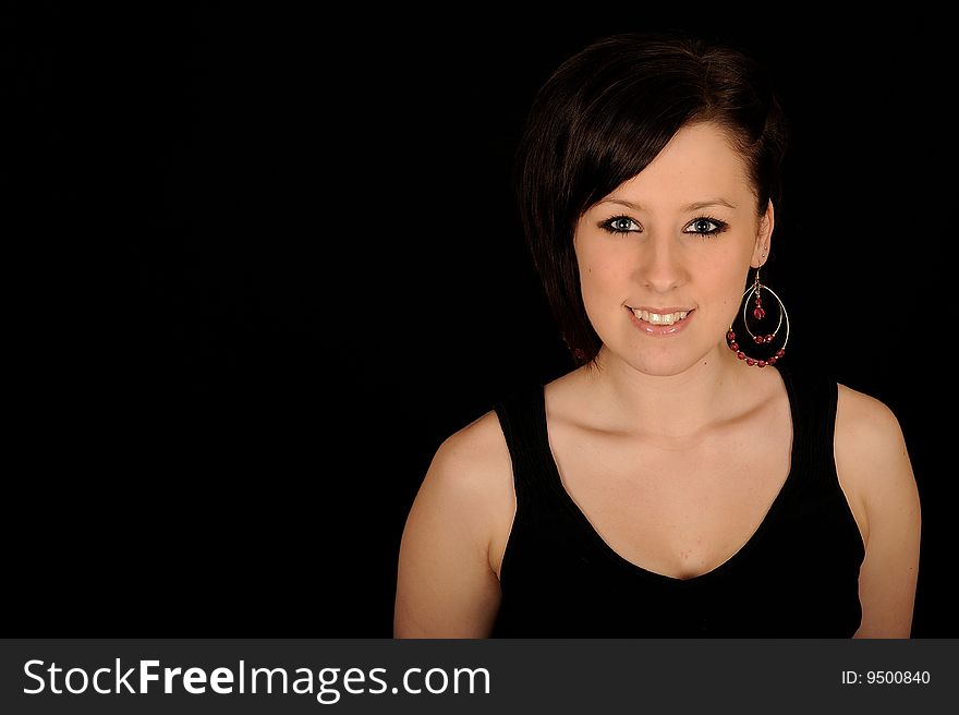 Horizontal closeup portrait of a smiling young woman, isolated against a black background. Horizontal closeup portrait of a smiling young woman, isolated against a black background.