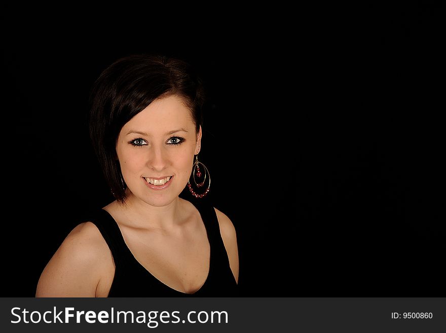 A formal portrait of a dark haired teenage girl.  Black background. A formal portrait of a dark haired teenage girl.  Black background