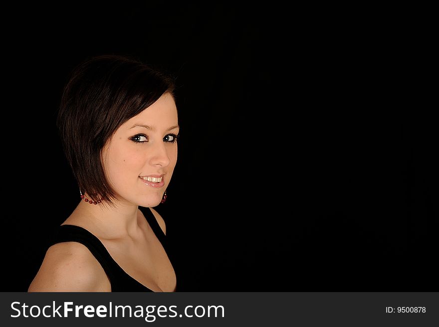 Horizontal closeup portrait of a smiling young woman, isolated against a black background. Horizontal closeup portrait of a smiling young woman, isolated against a black background.