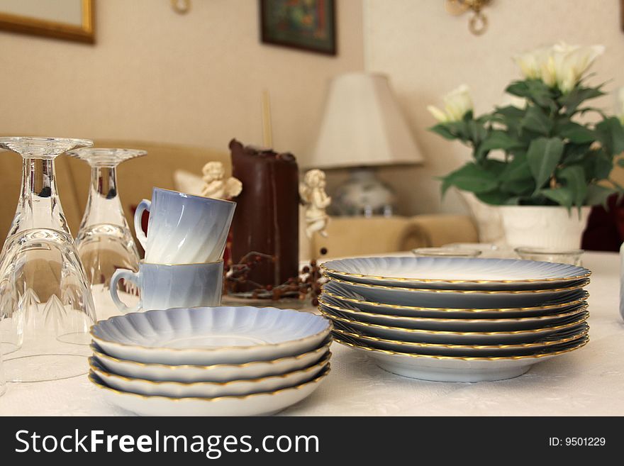 An up close image of crystal glasses, coffee cups and plates on a table. An up close image of crystal glasses, coffee cups and plates on a table.