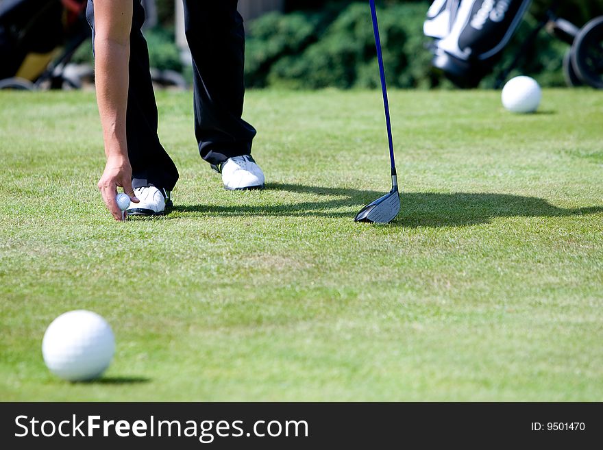 A male golfer is preparing to tee off. A male golfer is preparing to tee off.